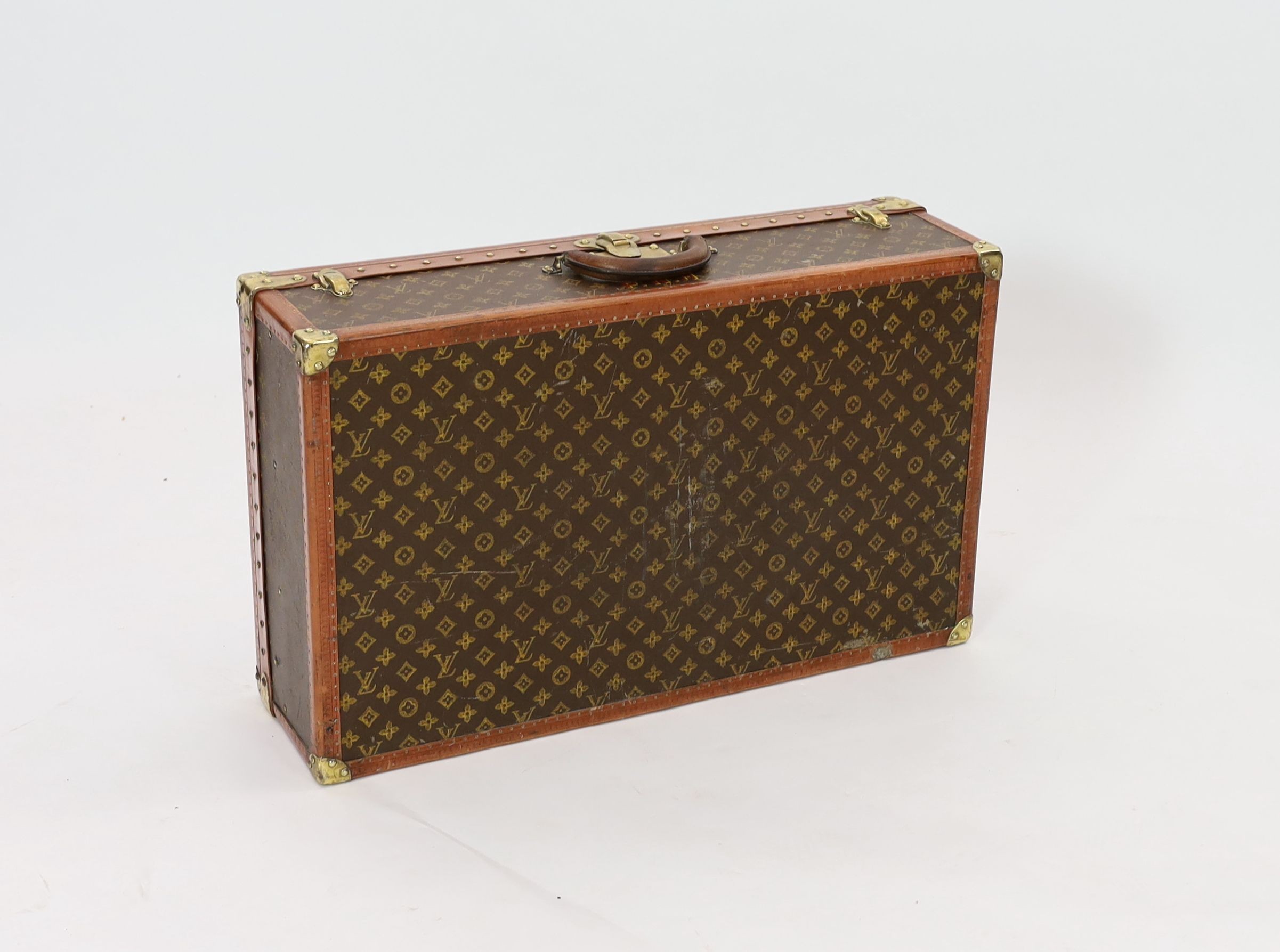 A Louis Vuitton brass mounted leather bound suitcase, 76 x 46cm depth 22cm